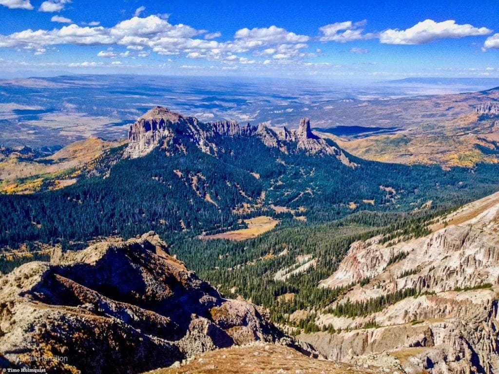 Photo 3: Courthouse Mountain and Chimney Rock from neighboring Precipice Peak. The Grand Mesa is the dark flat line against the upper right horizon. The La Sal Mountains of eastern Utah are visible as a ridgeline against the upper left horizon.
