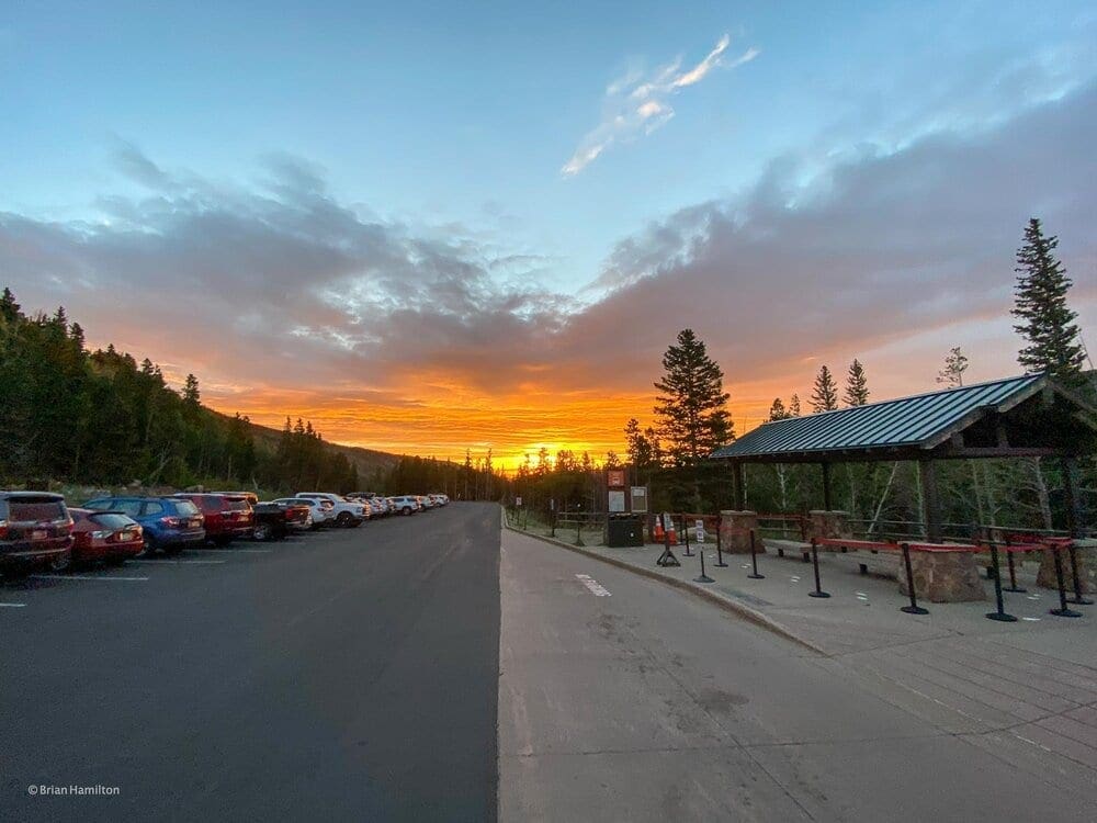 Photo 2: Arriving at the Glacier Gorge trailhead before sunrise is a must since the parking area fills up fast each morning. On this morning, the Rocky Mountain sunrise lit up the sky. Photo by Brian Hamilton