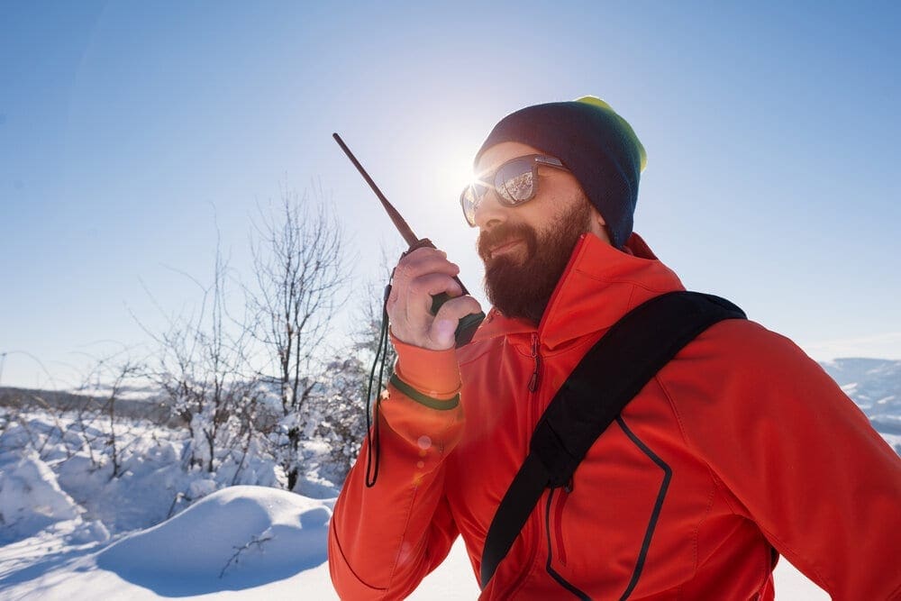Rescue man talking with portable radio on mountain snow landscap