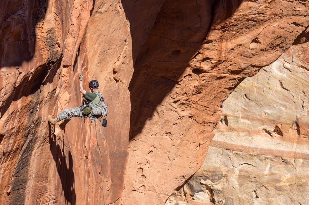 A climber rappels down a rock face in Capitol Reef National Park, Utah.